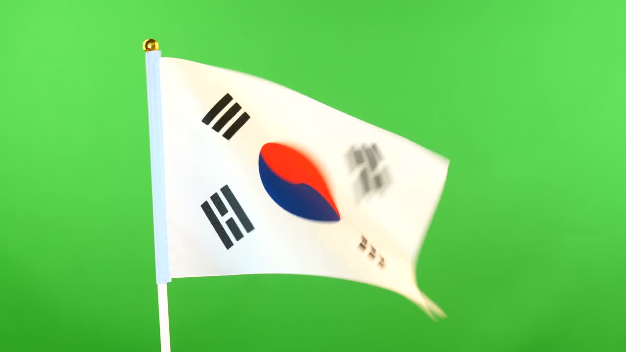 초록색 바탕에 있는 발 기둥에 한국의 발. 바람에 흔들리는 한국 발