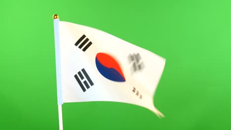 la bandera de corea en el mástil sobre un fondo verde. la bandera coreana ondeando en el viento.