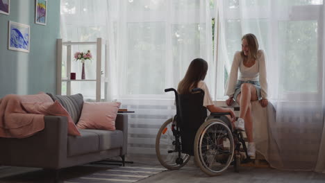 Blonde-woman-sits-on-windowsill-talking-to-disabled-partner