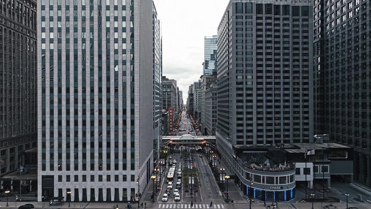 Carrellata aerea all'indietro su una singola strada nel centro città con la sua architettura iconica e i dintorni vivaci.