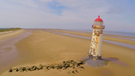 A-magnificent-vista-aérea-shot-of-the--Point-of-Ayr-lighthouse-in-Wales-with-weathered-fence-in-foreground-1