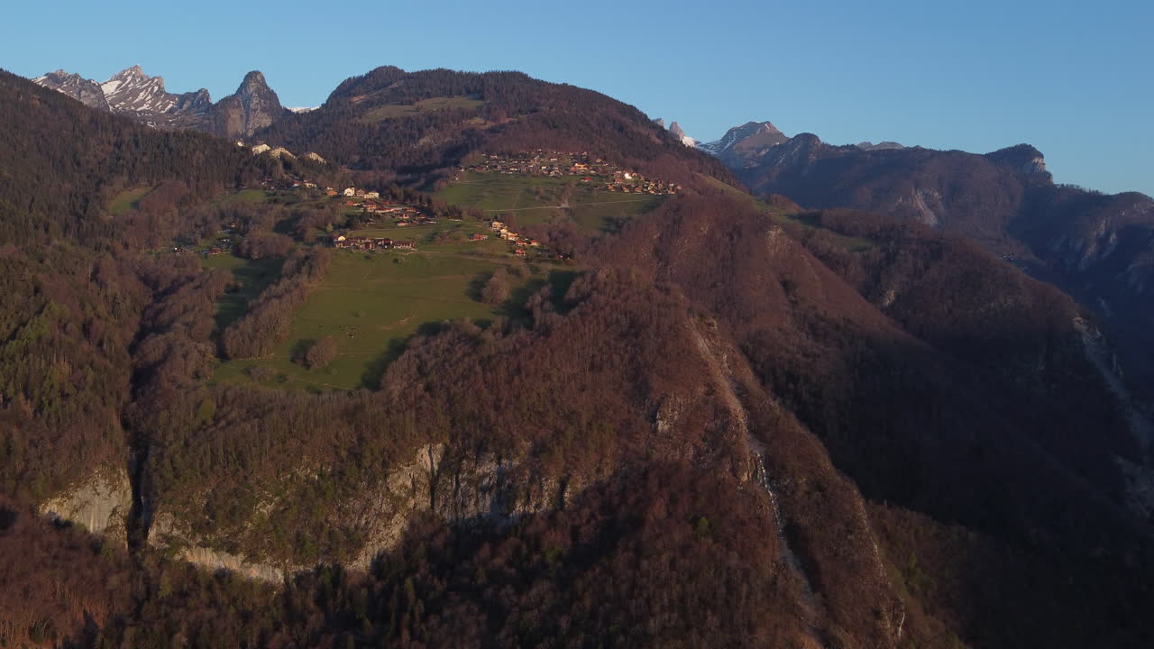 toma aérea lenta de un pueblo montañoso en los alpes cerca de vionnaz, suiza en un día soleado