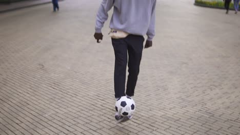 Un-Joven-Lanza-Una-Pelota-De-Fútbol-Con-Los-Pies