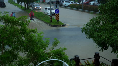 Cars-and-scooters-driving-through-the-flood-after-raining-very-heavy-in-Hat-Yai,-Thailand