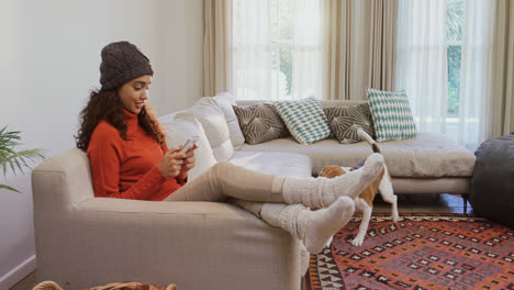 Dog-come-close-to-woman-sitting-on-sofa-while-using-her-mobile-phone-4K-4k