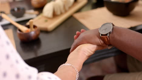 holding hands, senior friends enjoying meal together at restaurant table