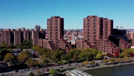 Fast-moving-drone-shot-of-apartment-high-rise-buildings-on-the-Harlem-River-in-New-York-City-in-bright-midday-sun