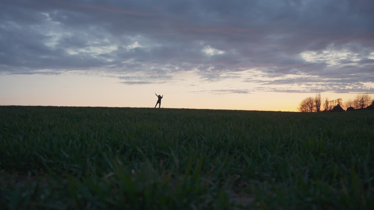 silueta chica bailando con alegría al atardecer