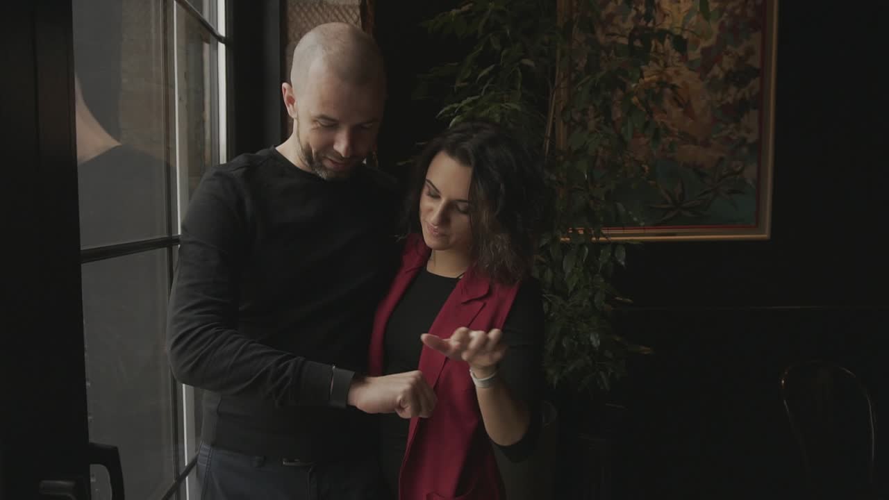Coppia che guarda uno smartwatch in un bar