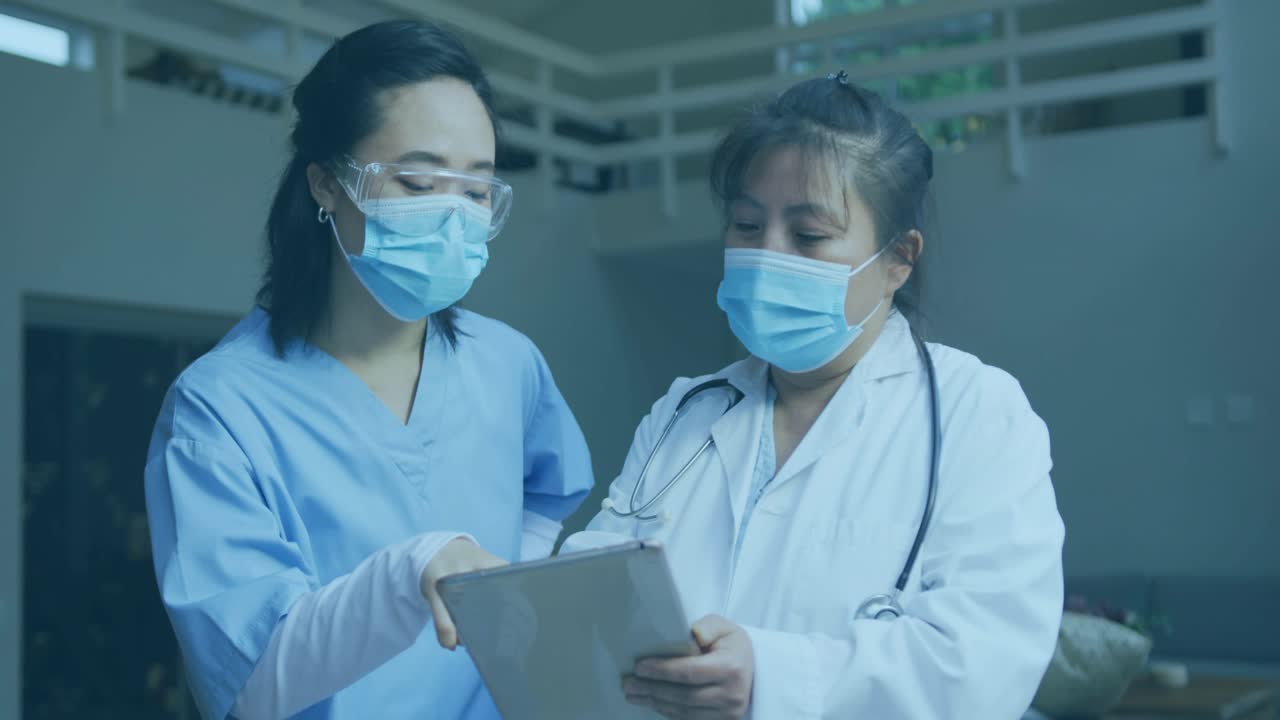 Two medical staff tapping tablet discussing patient data overlays appearing on Send Message prompt