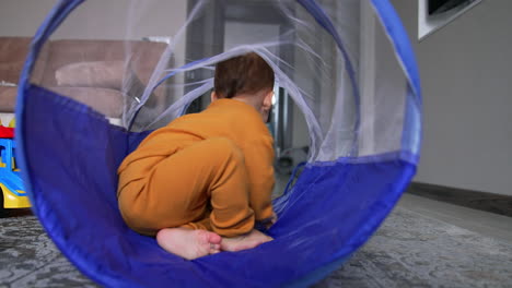 baby playing in a play tunnel