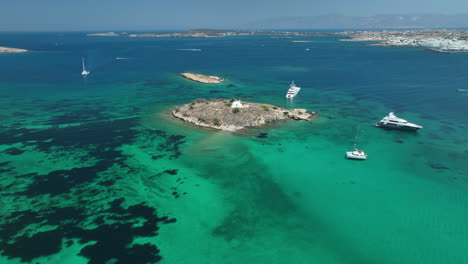 Aerial-views-over-a-small-church-on-a-secluded-Island-near-Paros-in-Greece