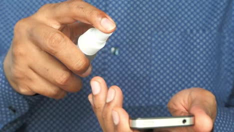limpieza de un teléfono inteligente con desinfectante de manos