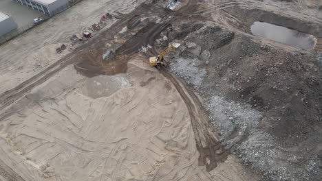 aerial of excavators collecting rubble from demolished building on construction site