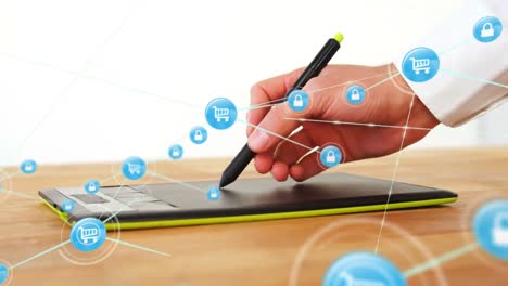 animation of connected icons over cropped hand of caucasian man drawing on graphics tablet