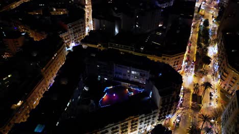 panning down shot of down town valencia , overlooking a rooftop garden all lit up for christmas