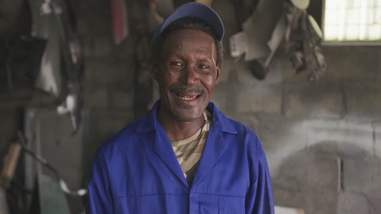 Old African handyman looking at camera