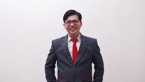 asian businessman standing while smiling looking at the camera