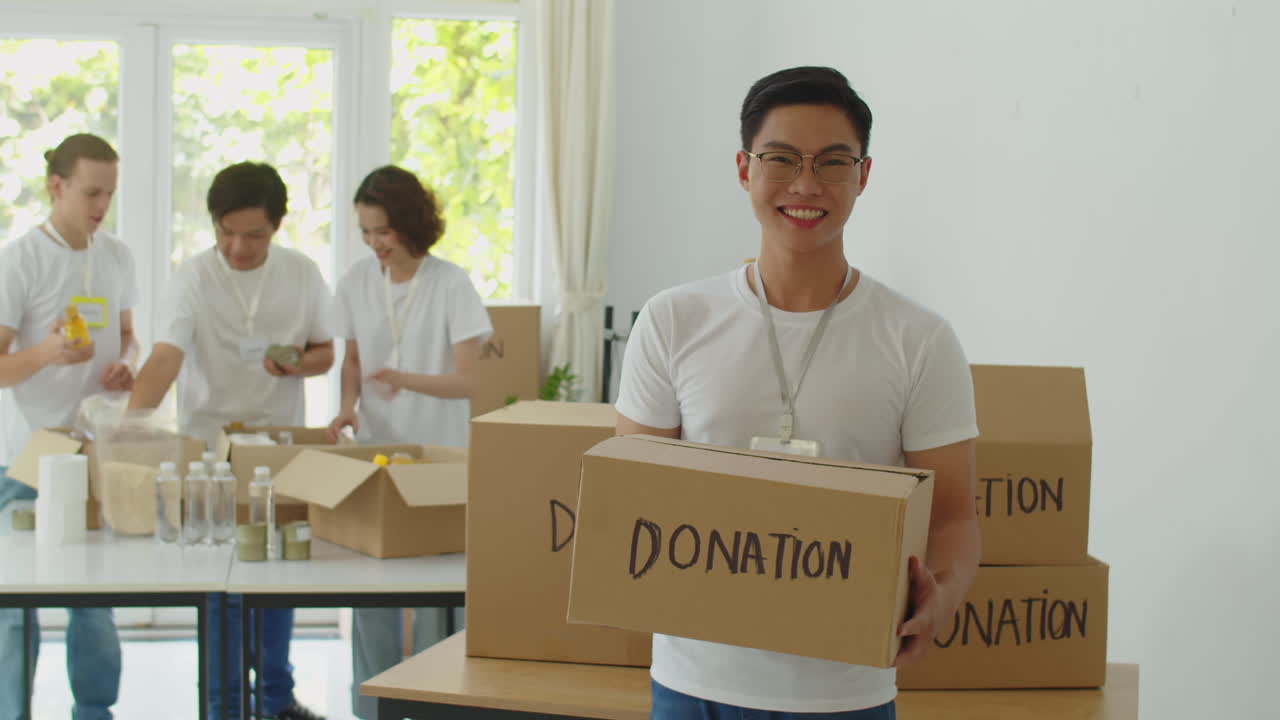 Cheerful Asian Volunteer with Donation Box