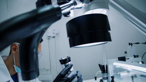 technician working with a high-precision microscope on circuit board