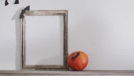 Video-of-frame-with-copy-space,-halloween-decorations-and-pumpkin-on-white-background