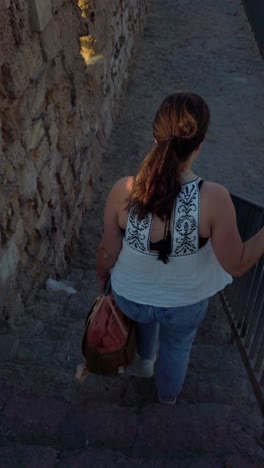 tourist walking down stone steps in acre old city, israel
