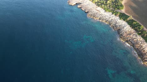 aerial drone view of serene seascape with rocky shore near sa coma, mallorca spain