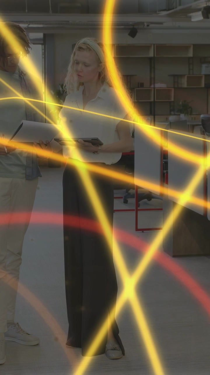 Video verticale: Personale d'ufficio che indica un tablet toccandolo, controllando le informazioni mentre anelli al neon scorrono