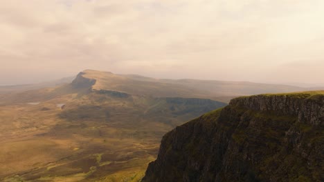Aerial drone footage of the dramatic mountain landscapes on the Isle of Skye, Scotland. Sweeping panoramic views of majestic peaks, green valleys, and wild nature