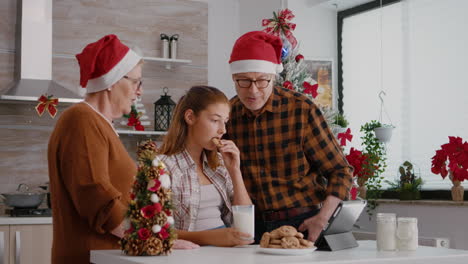 familia feliz viendo video de navidad de la infancia en línea usando una tableta