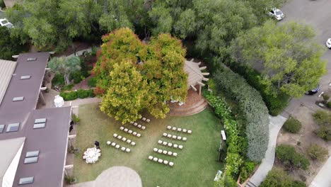 aerial view of an outdoor wedding celebration setup with white chairs on a green lawn