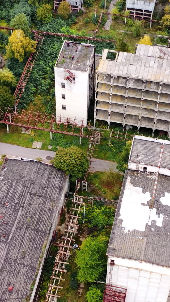 Old manufacture from above. Abandoned industrial territory with old buildings and warehouses. Empty factory. Orbital view.. Vertical video