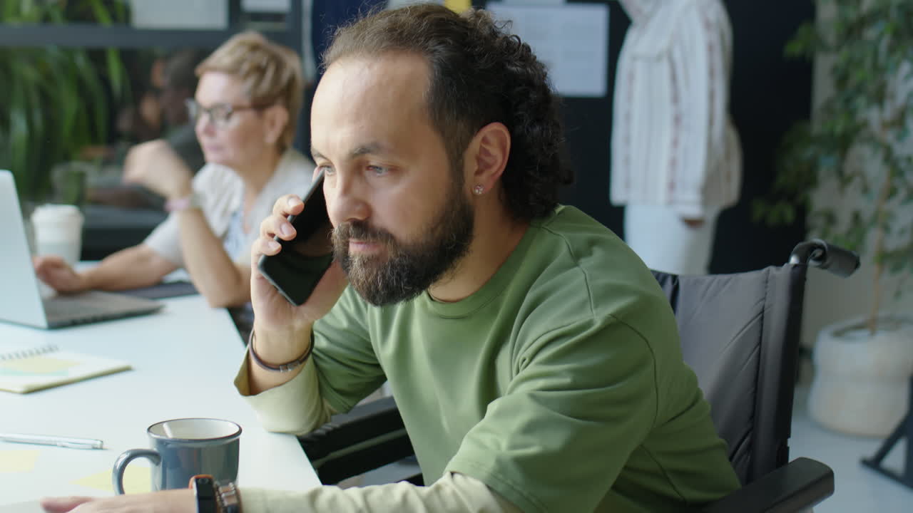 Uomo d'affari in sedia a rotelle che lavora in ufficio