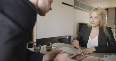 Young-Business-People-Having-Discussion-At-Table-In-Office