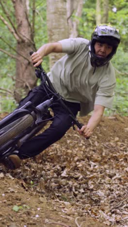 video vertical de un hombre en bicicleta de montaña ciclando a lo largo de un sendero de tierra a través del bosque 11