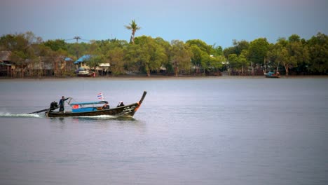 un bote motorizado de cola larga que transporta a lugareños y turistas a lo largo del río pak nam en krabi, tailandia