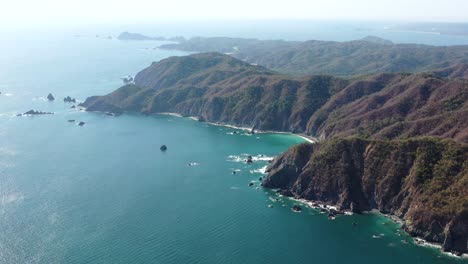 Stunning-aerial-view-of-mountains-and-blue-ocean-in-Mexico