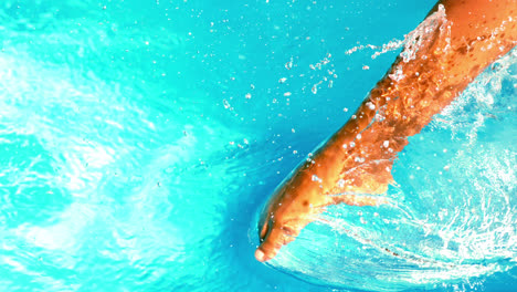 Pies-De-Mujer-Chapoteando-En-La-Piscina.