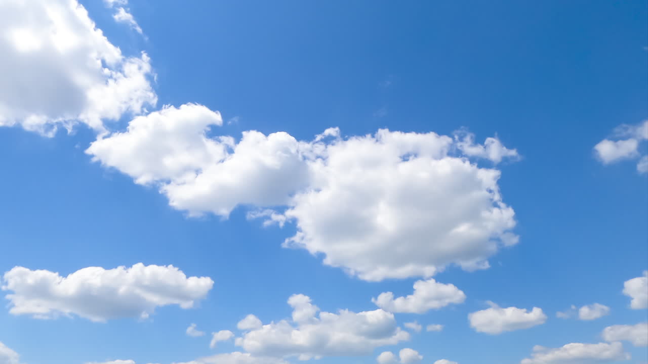 Fluffy little clouds in the blue skyline. Terrific timelapse of the cloudscape moving in the summer sky.