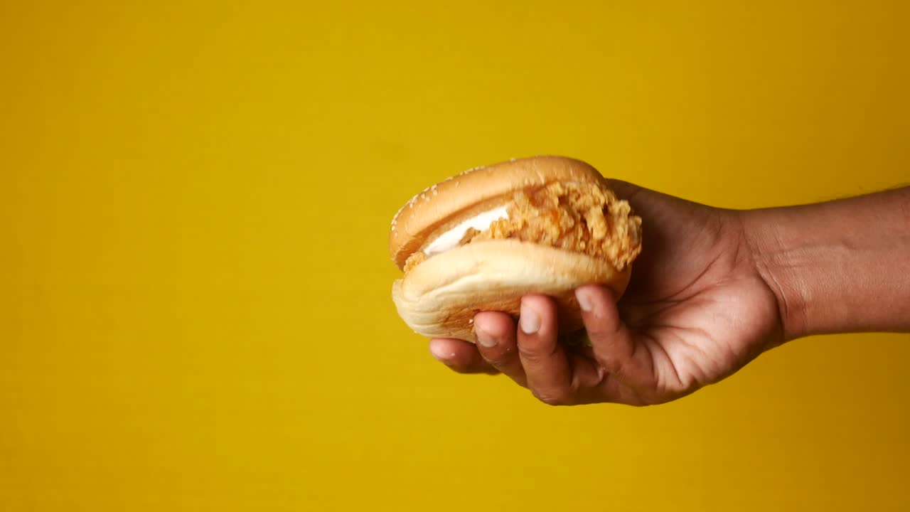 Hand Holding a Crispy Chicken Burger