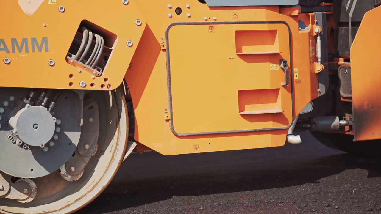 Road construction and repairing works. Close up view on the road roller working on the new road construction site