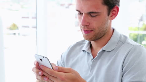 un hombre de negocios casual enviando mensajes de texto por teléfono.
