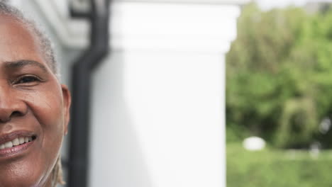 Half-portrait-of-happy-senior-african-american-woman-smiling-in-garden,-copy-space,-slow-motion