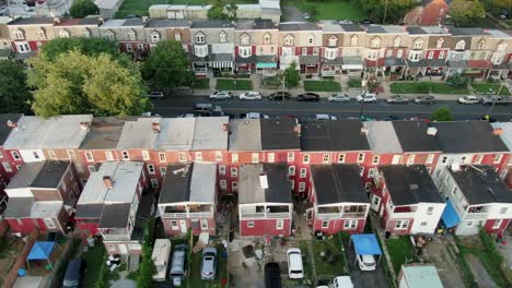 aerial establishing shot of row homes, houses tightly packed along street in usa, american housing real estate in urban america during magic hour