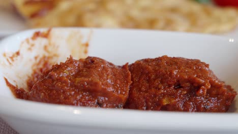 close-up of a spicy tomato dip in a dish, possibly meze