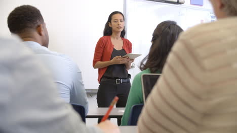 mujer hispana con tableta enseñando clase de educación para adultos