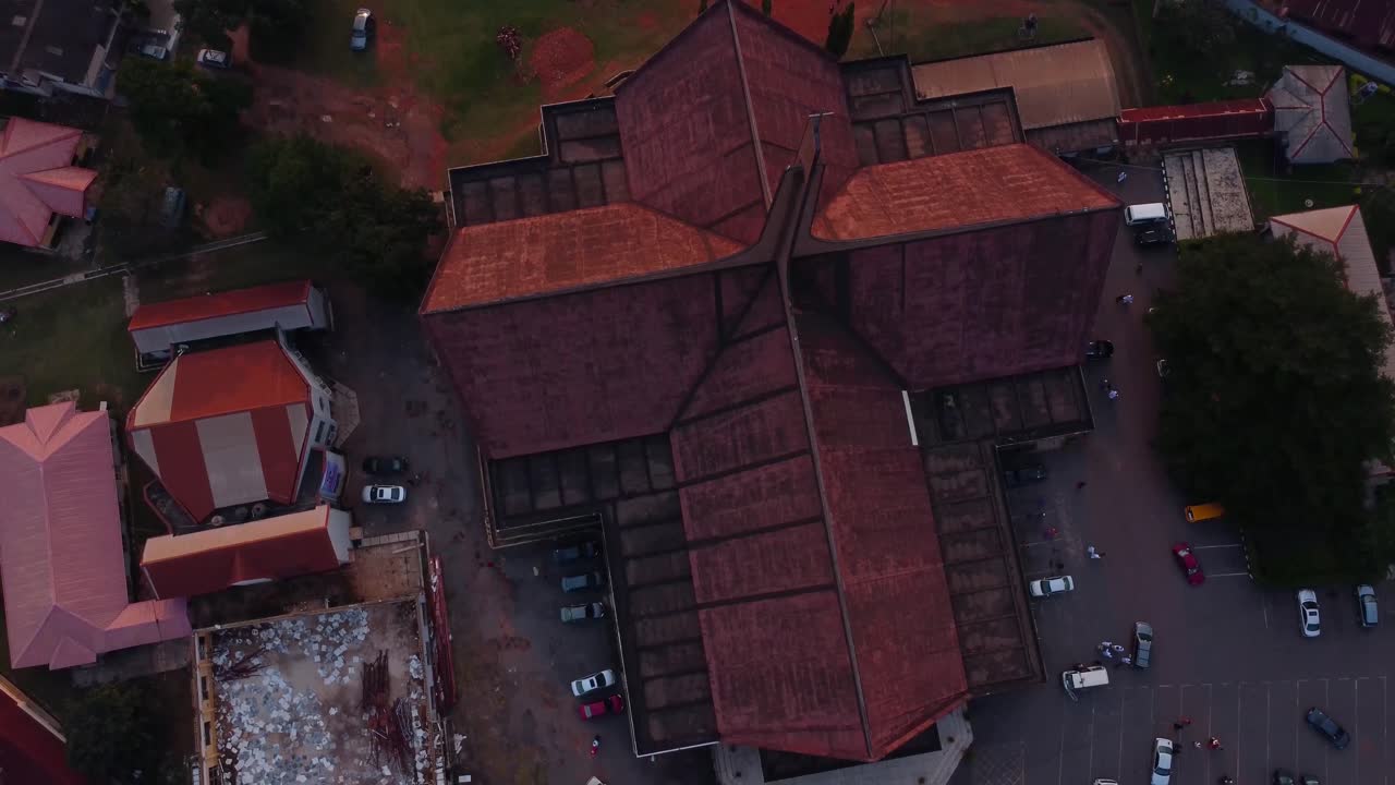 Stunning drone video capturing a bird's eye view of a historic church in Ibadan. The setting sun creates dramatic shadows and highlights the intricate architectural details