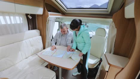 couples in rv camper looking at the local map for the trip.