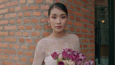 bride posing near brick wall