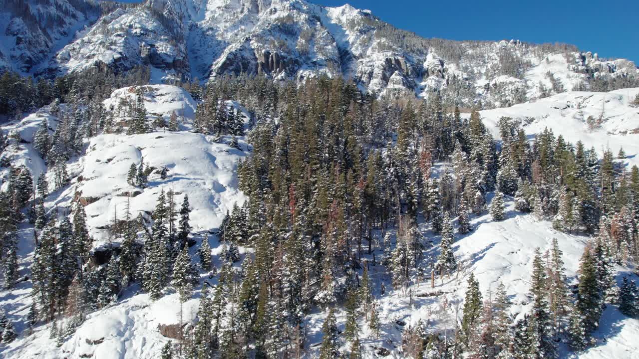 콜로라도 겨울의 가파르고 눈 덮인 산 절벽의 영화적 드론 공중 전망